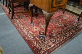 A Persian carpet, red ground with stylized decoration.