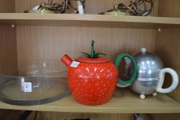 A glass bowl and two novelty teapots.