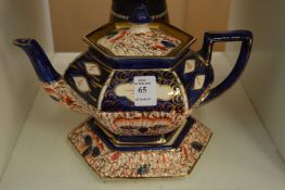 A lustre teapot on stand.