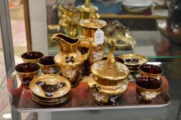A decoratively painted and gilded ruby glass tea service.