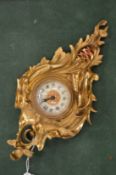 A miniature ormolu cartel clock.