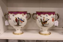 A good pair of porcelain twin handled pedestal ice pails decorated with exotic birds.