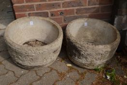 A pair of circular composite garden planters.