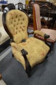 A Victorian carved rosewood framed button upholstered open armchair.
