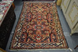 A Persian rug with large floral decoration.