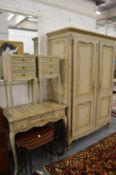 A decoratively painted French bedroom suite comprising two door wardrobe, dressing table and a