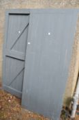 A pair of painted braced and ledged exterior doors.