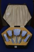 A cased silver and enamel dressing table set.