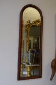 A pair of mahogany arch shaped mirrors.