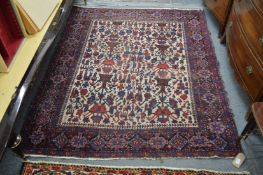 A Persian rug, cream ground with stylized decoration.