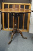 A mahogany tripod table with pie crust top on bird cage movement.