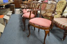 A set of four beech framed cane back dining chairs, two with arms.