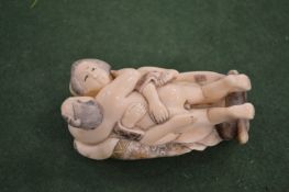 A carved erotic figure.