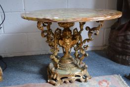 A circular onyx table on an ornate cast brass base.