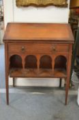 A Liberty & Co walnut bureau with a single drawer over an arcaded undertier (drawer with Liberty