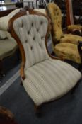 A Victorian walnut framed and button upholstered nursing chair.