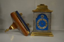 A miniature bracket clock with matching wall bracket.