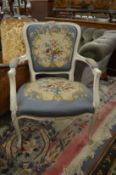A French style cream painted and needlework upholstered open armchair.