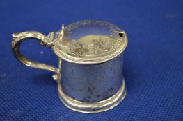 An engraved silver drum mustard.