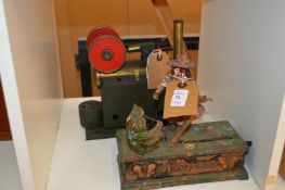 A cast iron money bank and a steam engine.