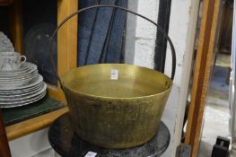 A brass preserve pan with wrought iron handle.