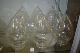 Nine teardrop shaped clear lampshades.