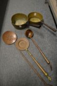 Two brass saucepans, an engraved copper ladle and two skimmers.