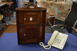 A miniature two door hanging corner cupboard.