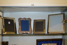 Four large silver plated photograph frames.