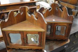 A pair of walnut small hanging corner cupboards.