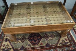 An eastern carved hardwood door converted to a coffee table with glass top.
