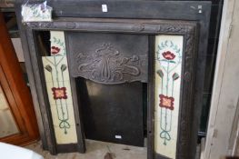 An Art Nouveau cast iron fireplace with porcelain inset tiles and later marble hearth.