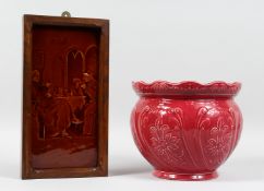A VICTORIAN TREACLE GLAZED TILE PANEL depicting figures at a table, in an oak frame, together with a