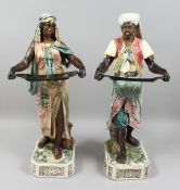 A VERY GOOD PAIR OF LARGE MAJOLICA POTTERY FIGURES OF AN ARAB MAN AND YOUNG GIRL standing holding