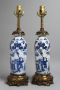 A PAIR OF CHINESE BLUE AND WHITE PORCELAIN LAMPS with ormolu mounts. 19ins high.