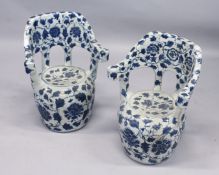 A PAIR OF CHINESE BLUE AND WHITE POTTERY GARDEN ARMCHAIRS. 26ins high.