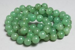 A STRING OF JADE BEADS, 32ins long.