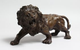 A BRONZED MODEL OF A SNARLING LION. 12.5ins long.
