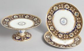 A SUPERB COALPORT COMPORT with A M D crest, with superb blue and gold border, painted with vignettes