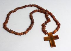 AN ETHNIC BEAD NECKLACE with crucifix and pendant, possibly rhino horn.