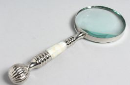 A MAGNIFYING GLASS with CHROME and MOTHER OF PEARL handle.