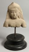 AN ANTIQUITY STONE FIGURE, POSSIBLY INDIAN. 10ins x 9ins on a stand