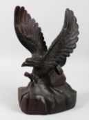 A CARVED WOOD MODEL OF AN EAGLE, wings and talons outstretched. 18ins high.
