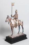 A GOOD WHITE METAL SOLDIER ON HORSEBACK carrying a pennant, a sword by his side. 11ins high, on a