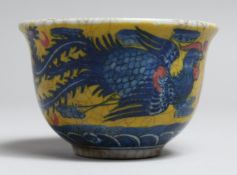A SMALL PORCELAIN TEA BOWL painted with a bird and dragon. 3.5ins diameter.