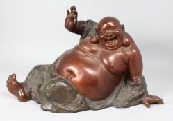 A LARGE BRONZE OF A HAPPY RECLINING BUDDHA. 24ins long.