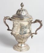 A GEORGE III LOVING CUP AND COVER with repousse decoration, cast acanthus scrolling handles and