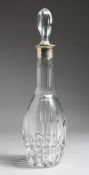 A CRYSTAL GLASS DECANTER AND STOPPER with silver band, engraved: Presented by Colonel N M Braisby