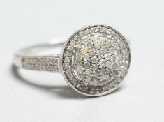 A 9CT WHITE GOLD DIAMOND CLUSTER RING.
