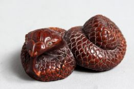 A CARVED WOOD SNAKE NETSUKE, 2ins long.